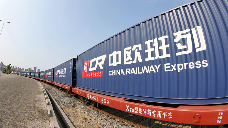 Speed Comparison: Rail Freight vs. Sea Freight China-Europe Express Railway speeding past a cargo ship